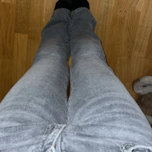 Grå bootcut jeans med fickdetaljer - Säljer ett par grå jeans med bootcut-modell och lågmidja me snygga fickdetaljer bak. 