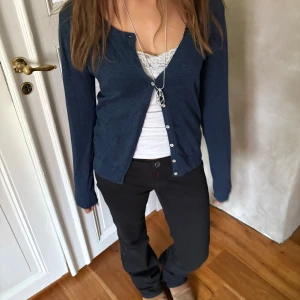 Mörkblå kofta - Säljer en mörkblå kofta med en unik detalj vid armbågarna som ger en extra snygg och personlig stil. Mjuk och bekväm, perfekt att använda både till vardags och vid lite finare tillfällen.