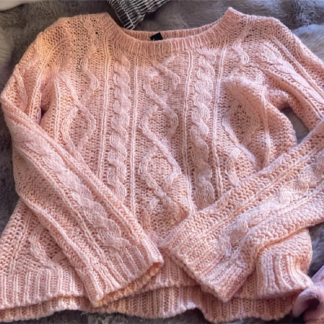 Ljusrosa stickad tröja med flätmönster