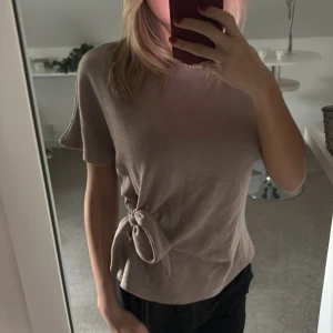 Beige topp med knyt i sidan - Säljer en beige topp från Zara, i storlek S💘tröjan är använd ett få antal gånger och är i mycket bra skick! 