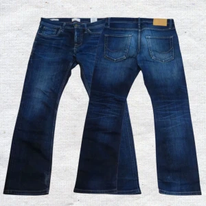 Blå jeans från Jack & Jones - Snygga blå jeans från Jack & Jones med klassisk femficksdesign och regular fit. Jeansen har en mörk tvätt med lätt slitning och raka ben. Perfekta för dig som gillar en tidlös och avslappnad stil.