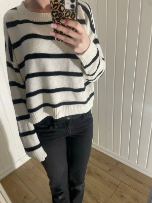 Stickad tröja - Säljer en stickad tröja i vitt med svarta ränder. Tröjan har rund halsringning, långa ärmar och ribbade muddar. Är i stolek xs💗