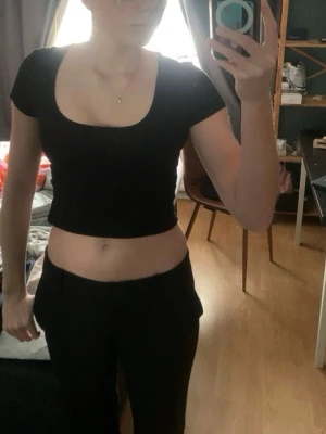Svart croppad topp - En svart croppad topp från Hm med en rundad uringning. Basic bomull topp med korta armar som funkar till de mesta. Toppen annvänd ett få tal gånger utan täcken på användning.