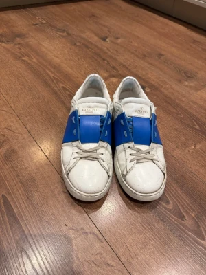 Valentino Garavani sneakers blå/vit -  Valentino Garavani som är äkta, dem är lite slitna men annars i bra skick, Nysydda vid sulan. Du får med box o allt annat!