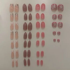 Mixade lösnaglar och tånaglar i nude-rosa alla för 100 ett par för 40 - Säljer flera set lösnaglar i olika former och färger, bland annat nude med leopardmönster, brunrosa mandelformade och rosa fyrkantiga. Vissa har vita blommor och andra har fransk design. Perfekt för dig som vill ha snygga naglar snabbt! Plastmaterial.