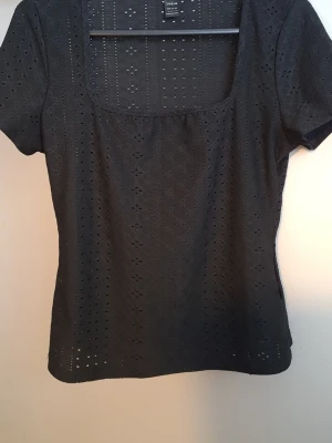 Topp  -  Svart topp i storlek L Hålmönster,fyrkantig ringning 