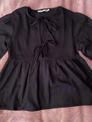 Festlig topp  - En svart topp där man kan knyta där fram och med puffärmar! Det var inte riktigt min stil så jag säljer den vidare:) 