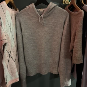 Ljusgrå stickad hoodie med huva (SÄNKT PRIS!!) - Supermjuk ljusgrå stickad hoodie med huva och snörning. Tröjan har en relaxed passform, bred ribbad mudd nertill och vid ärmslut. Helt oanvänd men orkade inte skicka tillbaka. Nypris 249. Pris går att diskuteras. Storlek 158/164