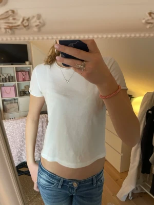 Vit croppad t-shirt från Zara - Säljer en jättefin, skön och croppad T-shirt från Zara. Köpt för ungefär ett år sen, men har tyvärr blivit för kort. 