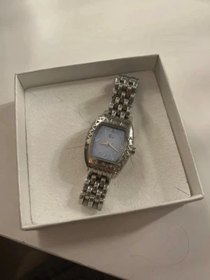 Elegant armbandsklocka i rostfritt stål - Stilren armbandsklocka i stainless steel (rostfritt stål) med länkarmband och dekorativ boett. Klockan har en ljus urtavla med tydliga siffror och ett elegant uttryck som passar både till vardag och fest. En klassisk modell som ger ett sofistikerat intryck. Observera att batteriet behöver bytas, klockan är därför inte i gång i nuläget.