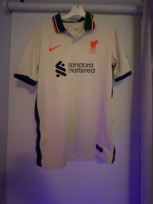 Liverpool tröja Nike  - Nike Liverpool tröja från någon säsong sedan. Fotbollströjan har en stilren look tack vare den gröna kragen och de röda detaljerna. Den köptes på unisport för några år sedan och säljer den nu för 149 kr.