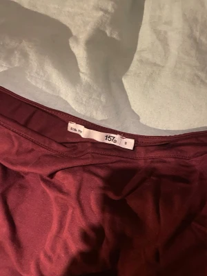 Vinröd ärmlös topp från 157 - Säljer en enkel och stilren vinröd topp från 157. Toppen är ärmlös med rund halsringning och har en rak passform. Tillverkad i mjukt bomullsmaterial som känns skönt mot huden. Perfekt att matcha med jeans eller kjol.