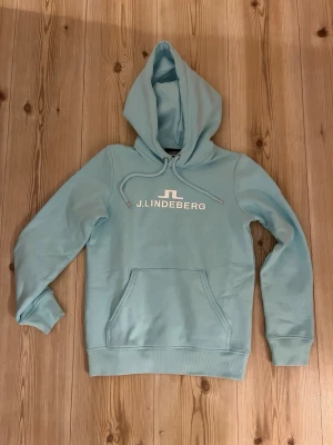J.Lindeberg Alpha hoodie -strl.XS - Snygg ljusblå hoodie från J.Lindeberg. Oanvänd