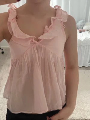 Rosa volang topp - Rosa topp med volanger och knuten i ryggen från gina Tricot i storlek 158-164. 