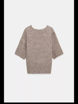 Beige stickad topp med knyt i ryggen - Superfin beige stickad topp från Zara med korta ärmar och snygg öppen rygg med knytband. Toppen är aldrig använd och har prislapp kvar❣️