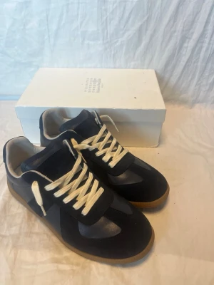 Maison margiela 43 - Ett par fina mörkblåa maison margiela i okej/använt skick, skickas med kvitto och låda. Passar 43 ganska bra och inga större skador, skriv vid någon fundering