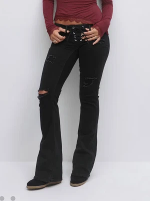 Svarta bootcut jeans med snörning - Snygga svarta jeans från gina 14+ som är slutsålda, använda två gånger! Har slitits lite längst ner på byxorna men inte något som märks jätte mycket.