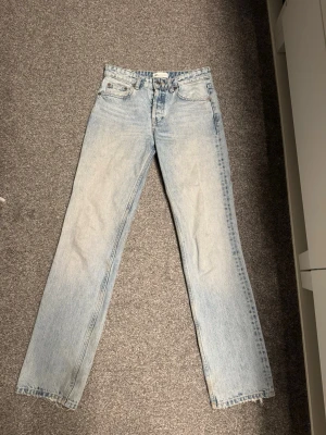 Ljusblå raka jeans från Zara - Säljer ett par ljusblå jeans från Zara i rak modell. Jeansen har klassisk femficksdesign, knapp och dragkedja fram samt bälteshällor. Materialet är jeans och färgen är snyggt tvättad för en cool look. Perfekta för dig som gillar enkel och stilren denim. Slutsåld modell med låg/medel midja.