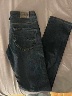 Lee jeans  - Säljer ett par mörkblå jeans från Lee, lågmidjade med raka ben. 150kr eller bud