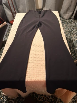 Svarta bootcut-byxor från H&M - Svarta bootcut-byxor från H&M i storlek S. Byxorna har en hög midja och är gjorda i ett stretchigt material med polyester och elastan. Snyggt utsvängda ben som ger en trendig siluett. Perfekta att styla med sneakers eller chunky boots.