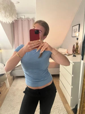 Ljusblå topp med öppen rygg- Gina Tricot - Säljer en ljusblå topp i mjukt bomullsmaterial från Gina Tricot. T-shirten är tight och har korta ärmar samt en snygg öppen rygg , perfekt att styla med ett par linnebyxor eller kjol ❤️‍🔥Str M, väldigt lite använd ✨