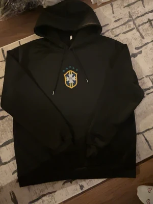 Brazil Tracksuit - Säljer en helt ny svart tröja med Brazil logon på, tröjan är i storlek M och ger dig en skön still perfekt för dig som gillar Brasilien. Om det är något du undrar skriv direkt. 🇧🇷