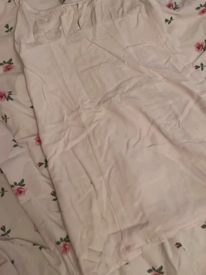 Vit kort klänning från Pull&Bear - Supersöt vit kort klänning från Pull&Bear med smala axelband och knyt i ryggen. Klänningen har en enkel och stilren design, perfekt för varma dagar. Väldigt liten i storlek, använda ca 5 gånger