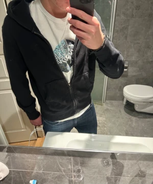 Svart hoodie med dragkedja - Svart hoodie med dragkedja från uniqlo. Riktigt bra skick på tröjan utan några defekter. Jag på bilden är 188cm och bör storlek S. Hör av er vid funderingar:)