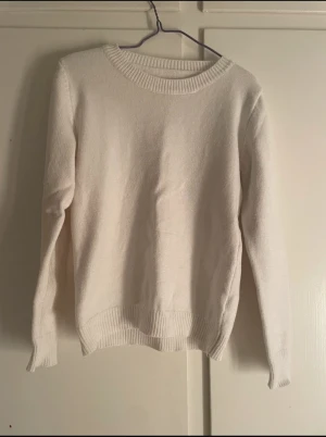 Vit stickad tröja från SHEIN - En enkel och stilren vit stickad tröja från SHEIN i storlek M. Tröjan har rund hals, ribbade muddar vid ärmslut och nederkant samt långärmad passform. Perfekt för dig som gillar en clean och klassisk look.
