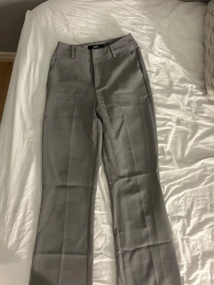 Grå kostymbyxor från BikBok, stl 34 - Snygga grå kostymbyxor från BikBok i storlek 34. Byxorna har raka ben och de är highwaist. Säljer då dom är för små