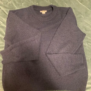 Mörkblå  stickad tröja med rund hals från Gina Tricot - En enkel och stilren mörkblå stickad tröja med rund halsringning och långa ärmar. Tröjan har ribbade muddar vid ärmslut och nederkant, perfekt för lager på lager under kyliga dagar. Den har ett mycket bra skick, bättre blå färg i verkligheten. Kontakta gärna för mer specifika bilder💕