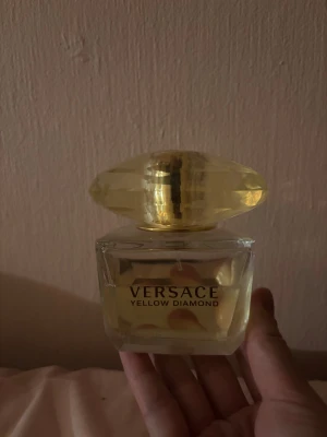 Versace Yellow Diamond parfym - Jättegod parfym från Versace. Uppskattar att det finns 70 milliliter kvar. Den har en fräsch blommig doft med inslag av citrus, päron och träiga toner. Originalpris 750kr. 