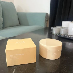 CAIA Silky Sensation Body Butter - Lyxig body butter från CAIA i en limited edition, Silky Sensation. Kommer i en beige rund burk med tillhörande ask. Innehåller sheasmör och macadamiaolja för extra återfuktning och silkeslen känsla på huden.