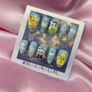 KawaiiSet (XS);Short Almond;Curved - Set med handgjorda press-on naglar i skimrande ljusblå färg, dekorerade med söta 3D kawaii djurmotiv som katt, kanin samt vita rosetter och detaljer. Naglarna har en kort mandelformad design och kommer i XS : 14 mm, 11 mm, 11,5 mm, 10 mm, 8 mm. Perfekt för dig som vill ha unika och kreativa naglar.