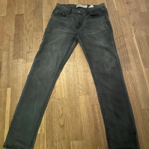 Levi's 512 svarta skinny jeans - Svarta Levi's 512 jeans med skinny fit och klassisk femficksdesign. Jeansen är tillverkade i en stretchig blandning av bomull, polyester och elastan för en bekväm passform. Snyggt smal siluett och diskreta detaljer, perfekta till din vardagsstil.