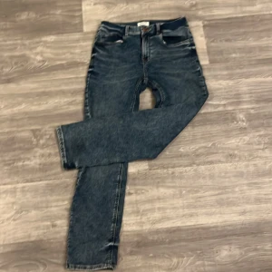 Mörkblå jeans från Lindex, stl 158 - Snygga mörkblå jeans från Lindex i klassisk femficksmodell. Jeansen har raka ben och normal passform, med cool tvättad look och kontrastsömmar. Perfekta för dig som gillar en enkel och stilren stil.