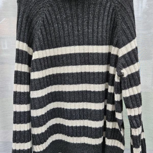 Randig ribbad stickad tröja M - Snygg stickad tröja med breda grå  och vita ränder. Ribbad struktur som ger en schysst känsla och extra komfort. Långärmad modell med klassisk passform, perfekt för dig som gillar enkel men stilren look. Passar dig som vill ha en chill och tidlös vibe.sprund i didsn polokrage. Från hm
