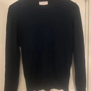 Mörkblå stickad tröja från Lindex - Mörkblå stickad tröja från Lindex med rund hals och långa ärmar. Snygga guldiga knappar vid ärmsluten ger en extra detalj. Perfekt för dig som gillar stilrena och klassiska plagg med en twist.