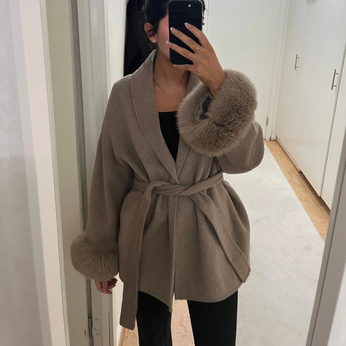 Beige kappa med pälsdetaljer
