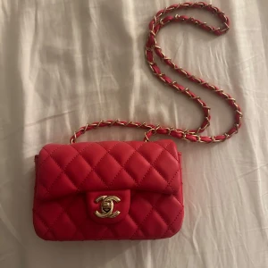 Röd quiltad axelväska - Säljer en snygg röd axelväska från med klassiskt quiltat mönster och guldfärgad kedja. Perfekt för dig som vill ha en lyxig och trendig accessoar. Använd 1-2 gånger, mycket bra skick. 