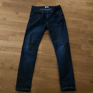Mörkblå jeans 405 regular fit 32/32 - Snygga mörkblå jeans från pearson Jeans i modellen 405 regular fit. Klassisk femficksdesign med raka ben och normal passform. Jeansen har kontrastsömmar och är tillverkade i slitstarkt denimtyg. Perfekt för dig som gillar en enkel och stilren look.