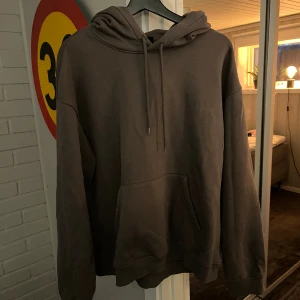 Brun oversized hoodie med huva - Mysig brun hoodie med stor huva och dragsko. Tröjan har en klassisk känguruficka framtill. Perfekt för chill dagar eller när du vill ha en avslappnad stil.