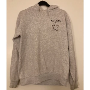Grå hoodie  - Grå hoodie med tryck från Gina tricot Young i storlek 158/164. Har en liten fläck men som knappt syns och förmodligen går att tvätta bort 