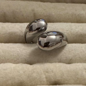 Chunky silverfärgad ring - Snygg chunky ring i silverfärgad metall med en cool, böjd design som ger ett modernt och stilrent intryck. Perfekt för dig som gillar statement-smycken och vill ha något som sticker ut. Passar både till jeans och dressat.