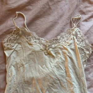Cremevit Spetslinne  - Spetslinne från vad jag tror är Lindex? (Lappen sitter inte kvar). Storlek S. Skrynklig, vilket borde gå att stryka ut. Tyget är blankt och antagligen polyester. 