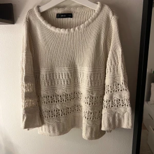 Beige stickad tröja från MNG - Säljer en beige stickad tröja från MNG med bred rund halsringning och snygga virkade detaljer. Tröjan har långärmade ärmar och ett loose fit som ger en chill vibe. Perfekt för dig som gillar boho-stil och vill ha något mysigt men ändå trendigt.