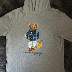 Polo Bear Ralph Lauren Long Sleeve - Polo Bear by Ralph Lauren Grå långärmad t-shirt med luva från Ralph Lauren  Storlek 170cm Mycket fint skick, nästan aldrig använd