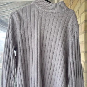 Grå ribbad stickad tröja från SHEIN - Säljer en grå ribbstickad tröja från SHEIN med hög krage och långa ärmar. 