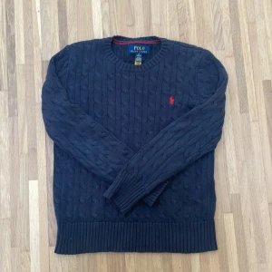 10-12 år tröja Ralph Lauren - Hejsan! Jag säljer min kabelstickade tröja från Ralph Lauren. Den säljs pga av att den är för liten på mig, men är i otroligt bra skick. Den finns nästan inget som tyder på användning och är i precis lika bra skick som att köpa en ny. Den är köpt på NK för 1.495,00 kr. Den har QR kod för att bekräfta att den är äkta. Skriv om du har några frågor!😁