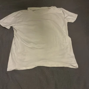Basic vit t-shirt i bomull - Enkel och stilren vit t-shirt med korta ärmar och rund hals. Perfekt för en clean och avslappnad look. Tillverkad i mjuk bomull som känns skön mot huden. Passar till det mesta och är ett måste i garderoben.